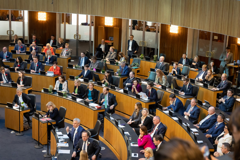 Blick von oben Richtung Sitzungsteilnehmer:innen, Fraktion GRÜNE und NEOS