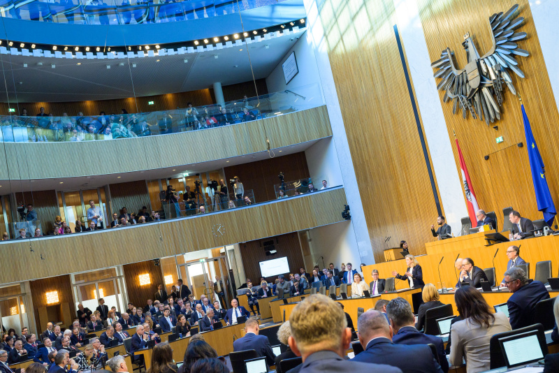 Blick Richtung Sitzungsteilnehmer:innen. Am Redner:innenpult: Klubobfrau Beate Meinl-Reisinger (NEOS)