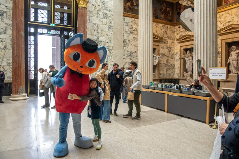 Maskottchen der Demokratiewerkstatt mit Besucher:innen