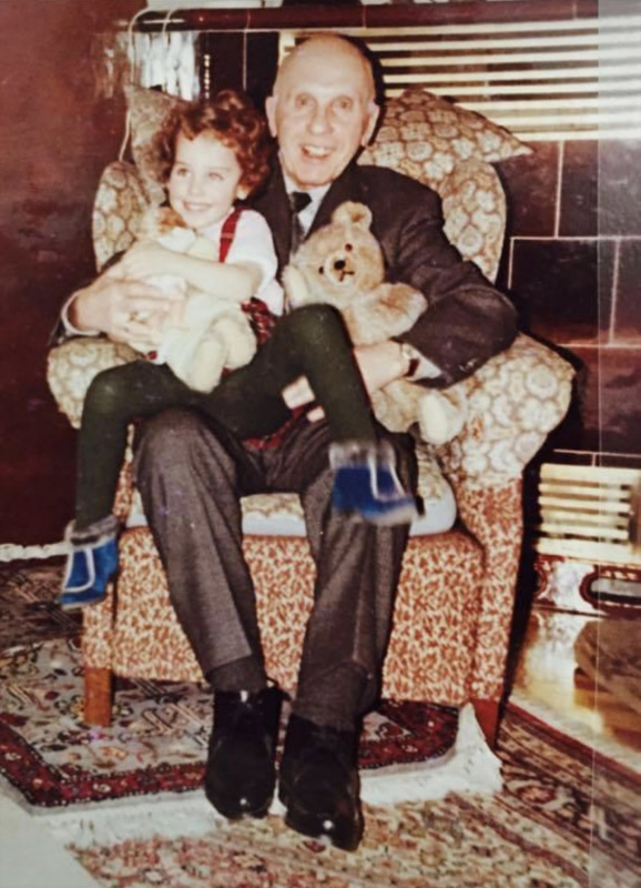 Marie-Christine Giuliani-Sterrer mit dem Großvater auf einem Sofasessel sitzend