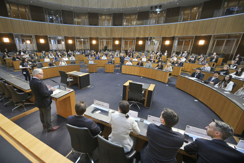 Begrüßung. Nationalratspräsident Walter Rosenkranz (FPÖ). Blick Richtung Veranstaltungsteilnehmer:innen