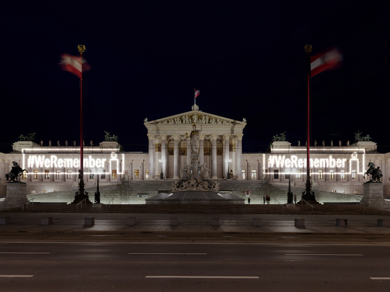 Projektion von #WeRemember auf die Fassade des Parlamentsgebäudes