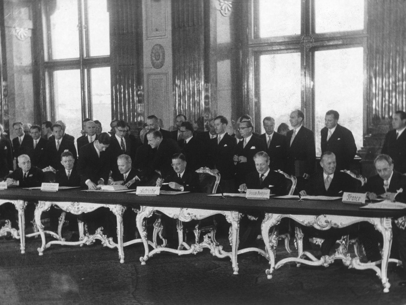 Sitzend v.l.:  US-Außenminister Foster Dulles, UdSSR-Botschafter Leonid Iljitschow, UdSSR-Außenminister Wjatscheslaw Molotow, Außenminister Leopold Figl, britischer Außenminister Harold Macmillan, französischer Außenminister Antoine Pinay, französischer Botschafter Roger Lalouette.