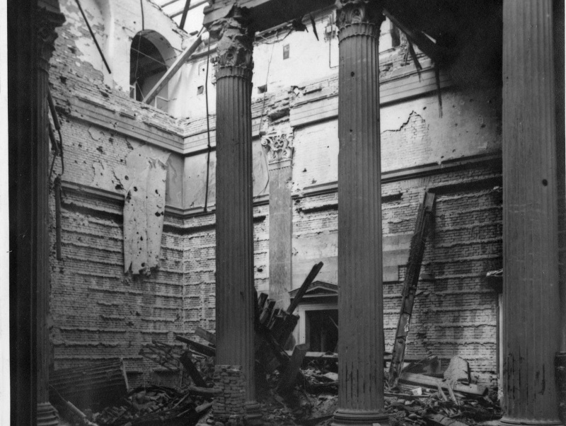 Blick in die NW-Ecke der durch einen Bombentreffer schwer beschädigten Säulenhalle. Die schwersten Gebäudeschäden erfolgten durch Bombentreffer am 7. und 21. Februar 1945 sowie durch Kampfhandlungen bei der Befreiung Wiens durch die Rote Armee. Gelegte Brände durch abziehende NSDAP-Bedienstete (Verbrennung von Akten).