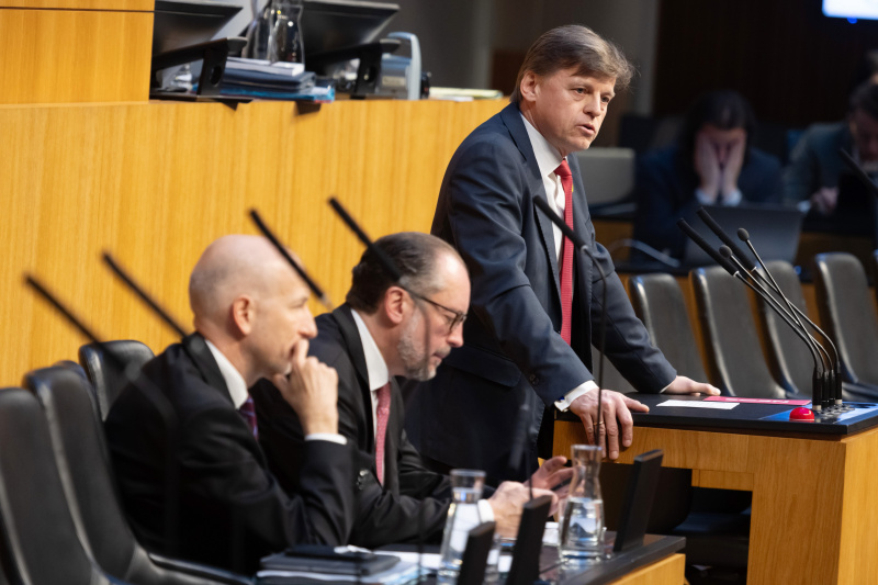 Am Redner:innenpult: Nationalratsabgeordneter Veit Valentin Dengler (NEOS). Auf der Regierungsbank von rechts: Außenminister und Bundeskanzler Alexander Schallenberg (ÖVP), Bundesminister für Arbeit Martin Kocher (ÖVP)