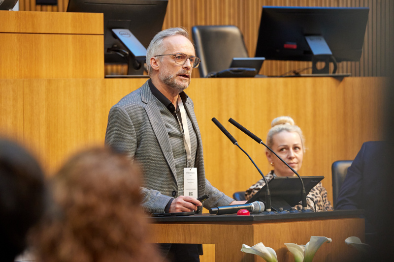 Präsentation. Am Redner:innenpult: Michael Mellitzer - Diakonie Kärnten