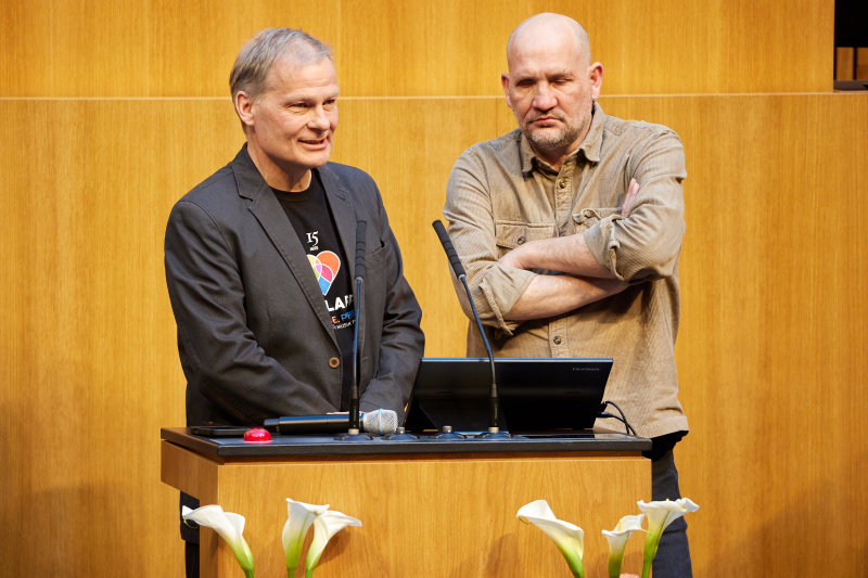 Präsentation. Am Redner:innenpult von links: Thorsten Hesse - Handiclapped, Fred Plohr - Pink Music