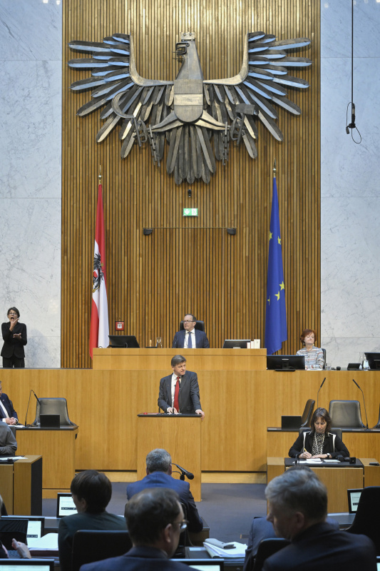 Am Redner:innenpult: Nationalratsabgeordneter Veit Dengler (NEOS). Blick Richtung Sitzungsteilnehmer:innen