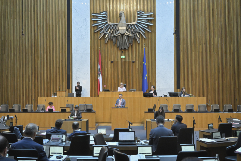 Am Redner:innenpult: Nationalratsabgeordneter Christoph Pramhofer (NEOS). Blick Richtung Sitzungsteilnehmer:innen