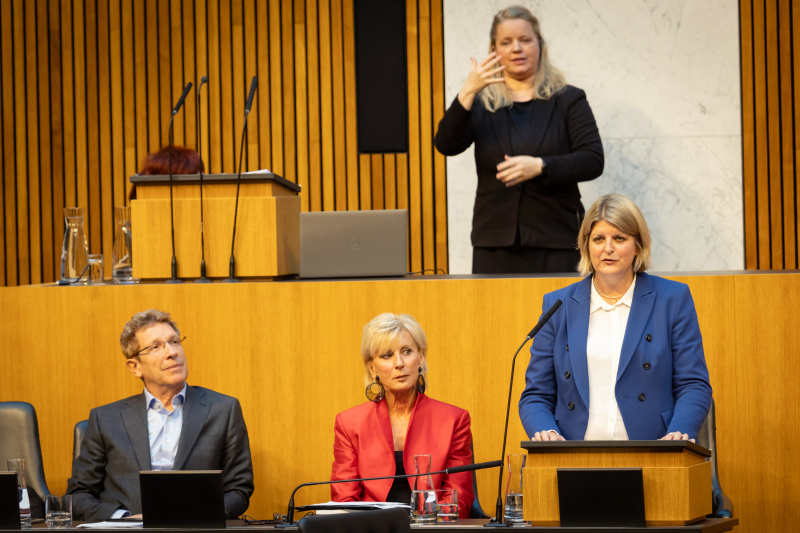 Am Redner:innenpult Volksanwältin Elisabeth Schwetz. Auf der Regierungsbank von rechts:  Volksanwältin Gaby Schwarz und Volksanwalt Bernhard Achitz