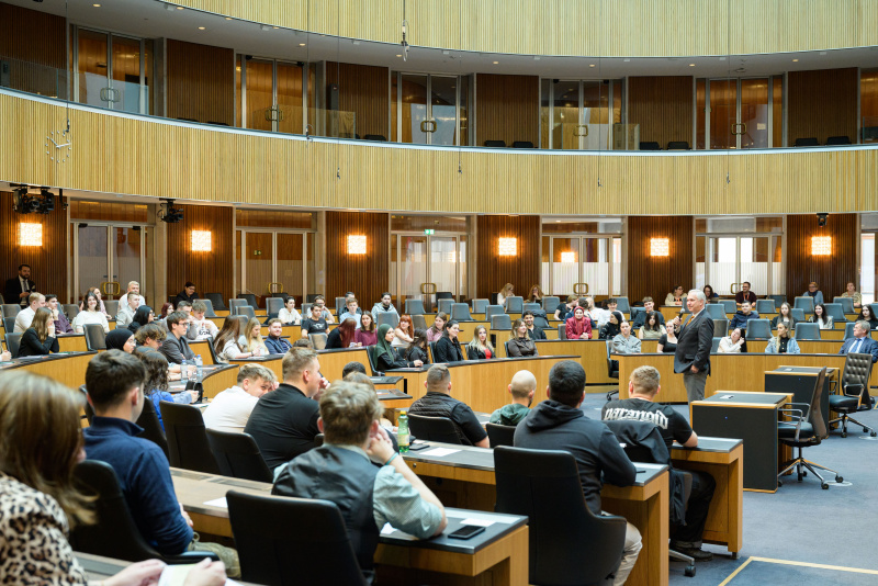 Begrüßung. Nationalratspräsident Walter Rosenkranz (FPÖ). Blick Richtung Veranstaltungsteilnehmer:innen