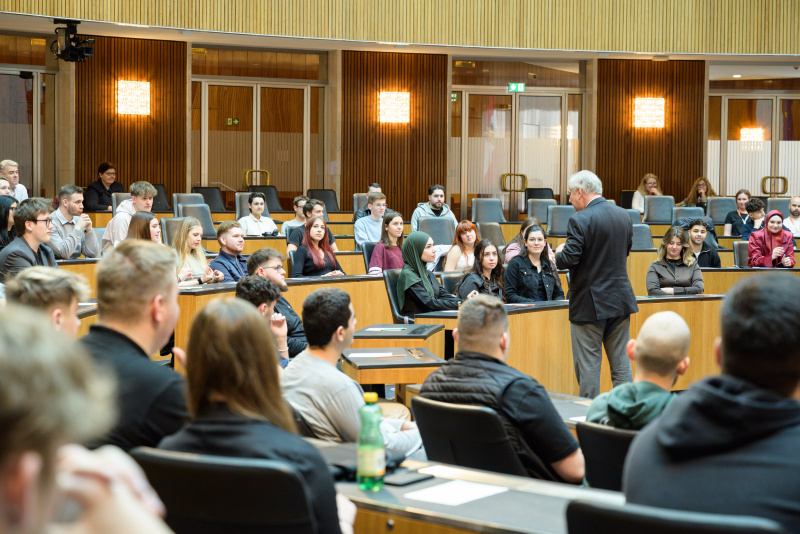 Blickrichtung Verasntaltungteilnehmer:innen. Begrüßung. Nationalratspräsident Walter Rosenkranz (FPÖ)