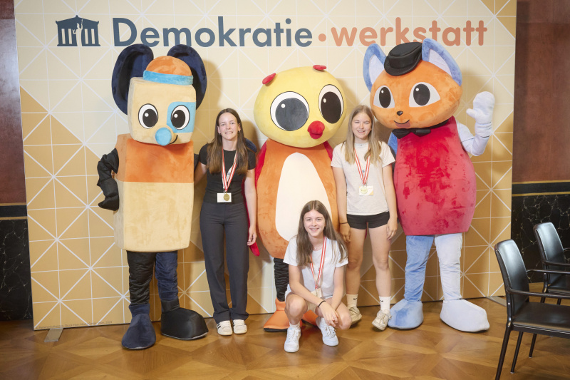 Schüler:innen mit den Maskottchen der Demokratiewerkstatt