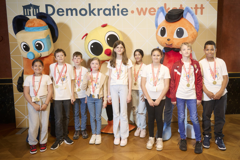 Schüler:innen mit den Maskottchen der Demokratiewerkstatt