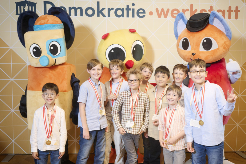 Schüler:innen mit den Maskottchen der Demokratiewerkstatt