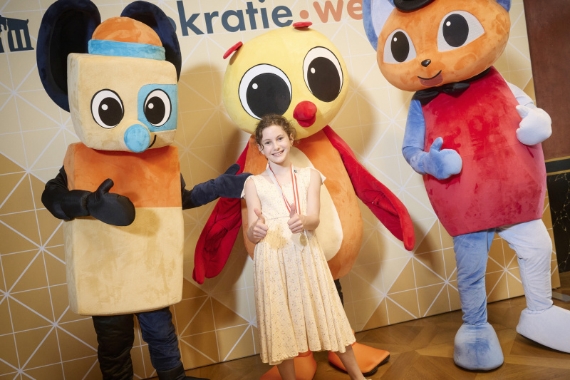 Schüler:innen mit den Maskottchen der Demokratiewerkstatt