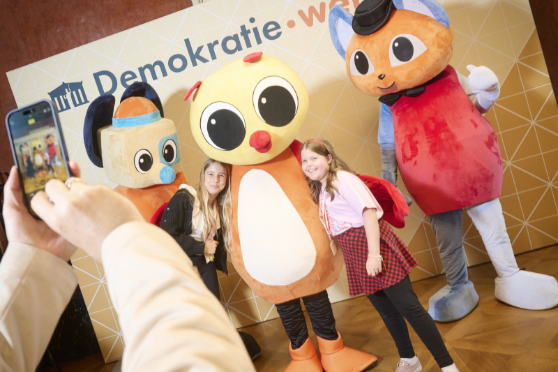 Schüler:innen mit den Maskottchen der Demokratiewerkstatt