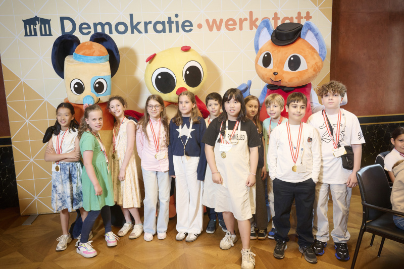 Schüler:innen mit den Maskottchen der Demokratiewerkstatt