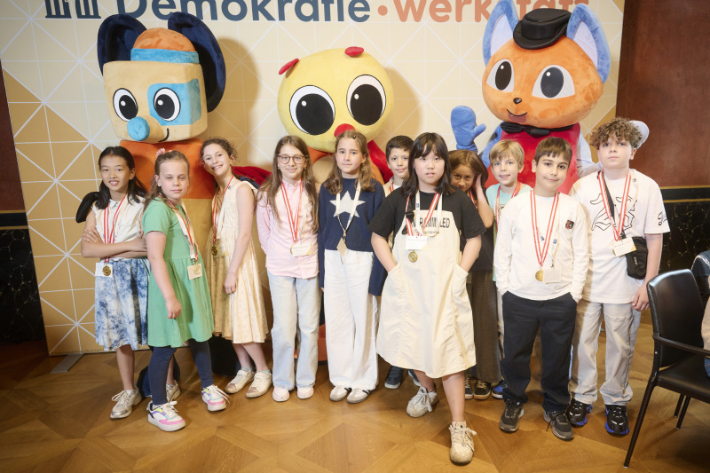 Schüler:innen mit den Maskottchen der Demokratiewerkstatt