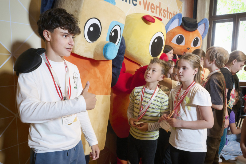 Schüler:innen mit den Maskottchen der Demokratiewerkstatt