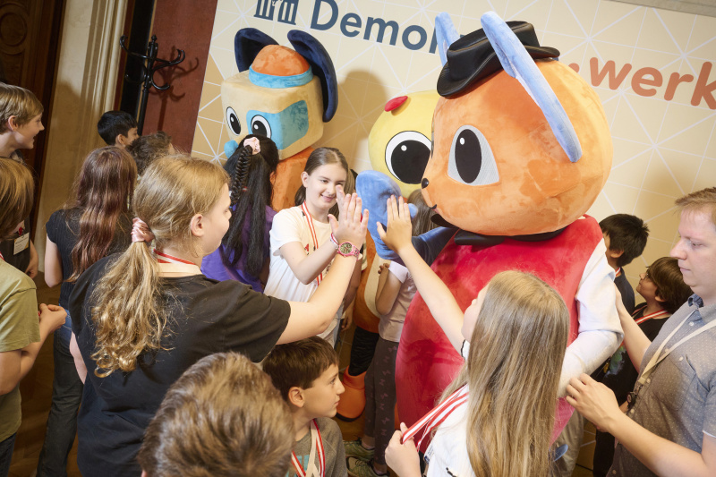 Schüler:innen mit den Maskottchen der Demokratiewerkstatt