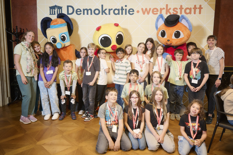 Schüler:innen mit den Maskottchen der Demokratiewerkstatt