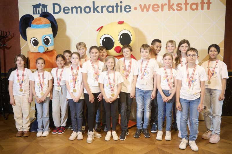 Schüler:innen mit den Maskottchen der Demokratiewerkstatt