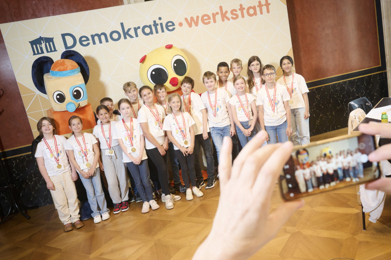Schüler:innen mit den Maskottchen der Demokratiewerkstatt