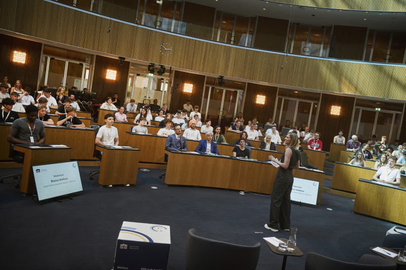 Moderation. Bianca Ambros. Blick Richtung Veranstaltungsteilnehmer:innen