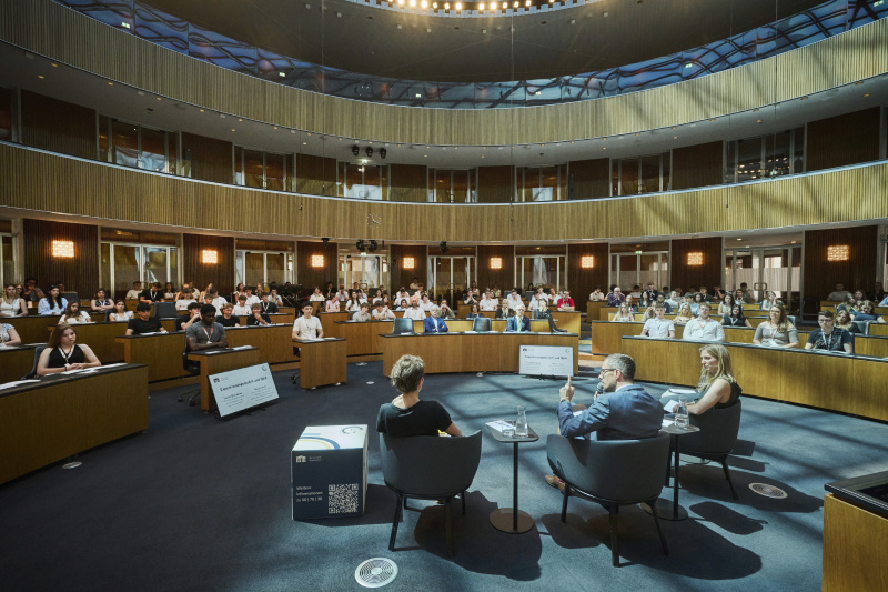 Expert:innengespräch. Blick Richtung Veranstaltungsteilnehmer:innen