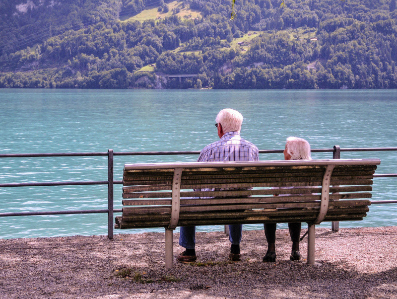 Pensionisten auf einer Parkbank vor einem See