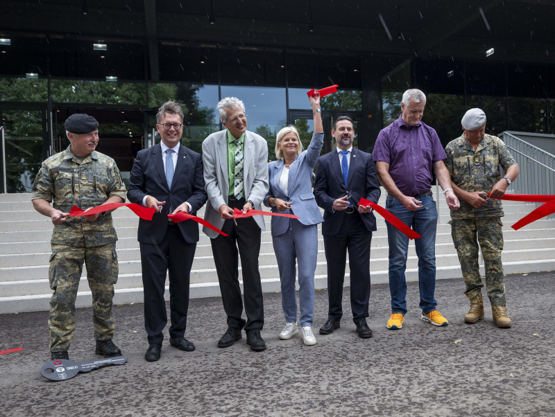 Klaudia Tanner und andere bei der Eröffnung des neuen Gebäudes. Sie halten ein zerschnittenes rotes Band.