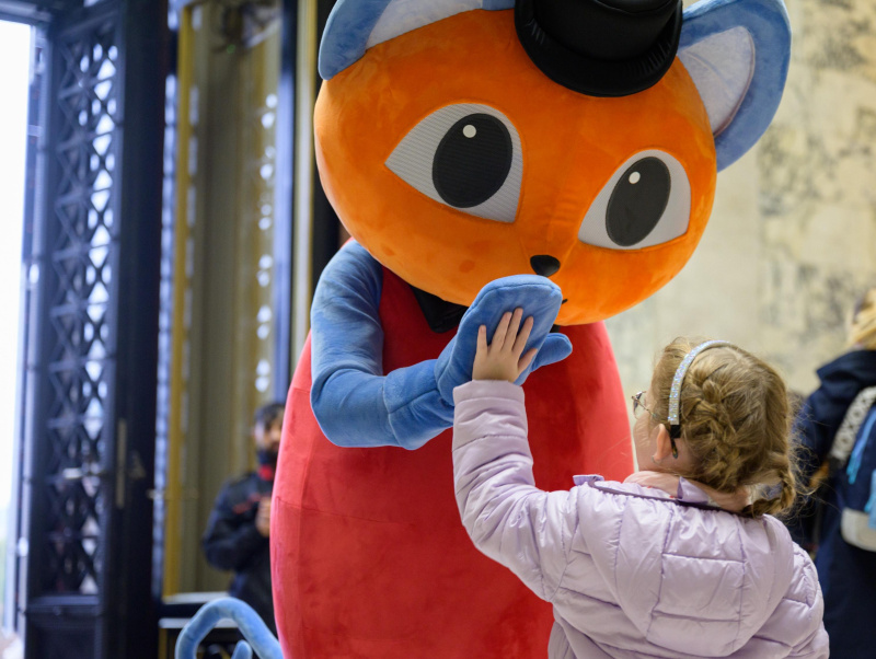 Foto von Maskottchen Polli und einem Kind