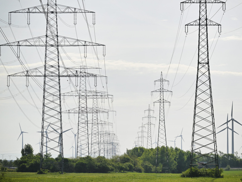 Mehrere Strommasten in der Landschaft.