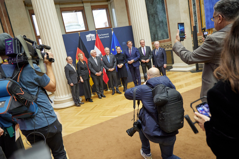 Fahnenfoto. 1. von links: Zweiter Nationalratspräsident Peter Haubner (ÖVP), 3. von links:  Bundespräsident der Bundesrepublik Deutschland Frank Walter Steinmeier, 4. Von links: Nationalratspräsident Walter Rosenkranz (FPÖ), 5. von links: Nationalratsabgeordnete Lisa Schuch-Gubik (FPÖ), 6. von links: Nationalratsabgeordneter Rudolf Silvan (SPÖ)