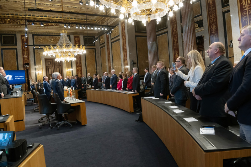 Bundeshymne. Blick Richtung Veranstaltungsteilnehmerinnen und -teilnehmer