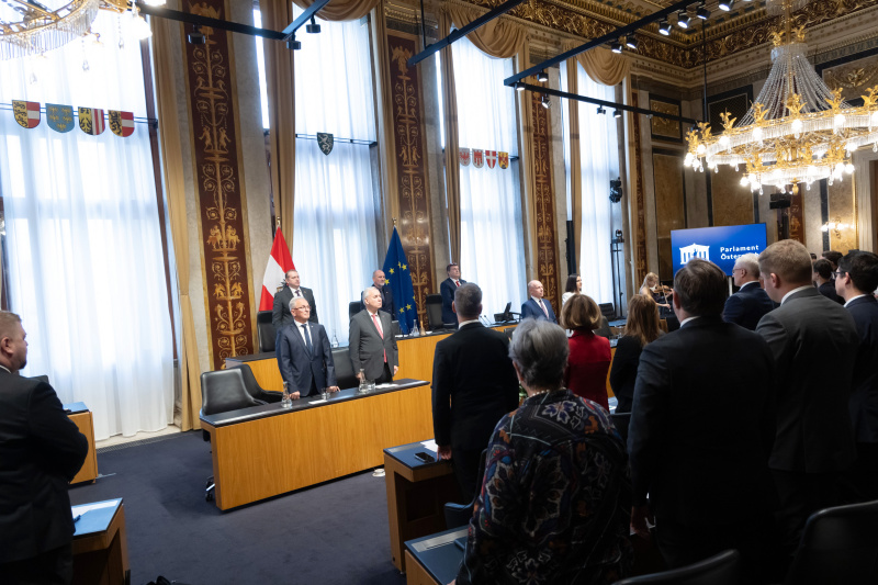 Bundeshymne. Blick Richtung Veranstaltungsteilnehmerinnen und -teilnehmer