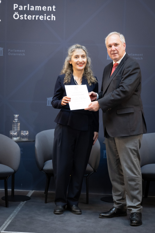 Überreichung der Urkunden durch Nationalratspräsident Walter Rosenkranz (FPÖ). Preisträgerin Universitätsprofessorin für Politik & Geschlecht, Diversität & Gleichheit Zoe Lefkofridi