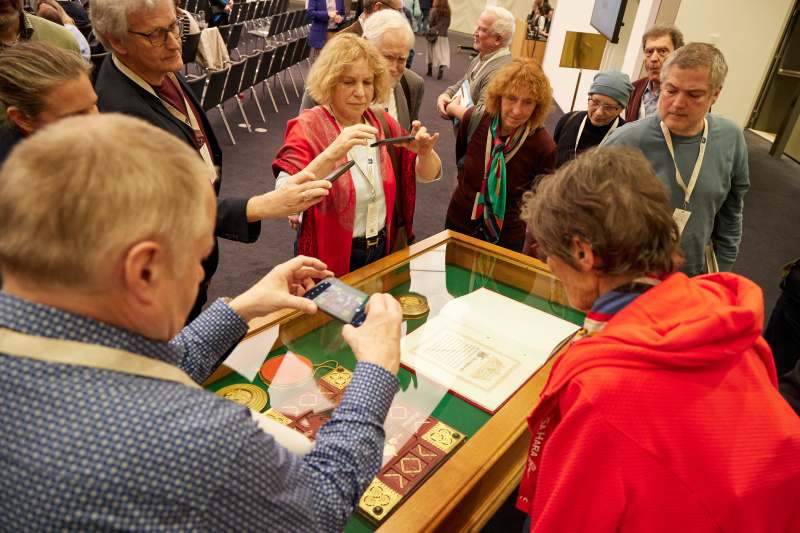 Veranstaltungsteilnehmerinnen und -teilnehmer fotografieren das Februarpatent von 1861