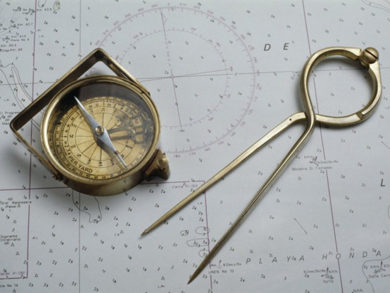 Compass and dividers on a map. These two devices are used in simple navigation