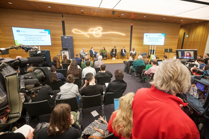 Podiumsdiskussion. Von links: Sprecher der Parlamentsdirektion Karl-Heinz Grundböck, Nationalratsabgeordneter Sebastian Schwaighofer (FPÖ), Nationalratsabgeordnete Carina Reiter (ÖVP), Nationalratsabgeordneter Paul Stich (SPÖ), Nationalratsabgeordneter Johannes Gasser (NEOS), Nationalratsabgeordnete Barbara Neßler (GRÜNE). Blick Richtung Veranstaltungsteilnehmerinnen und -teilnehmer