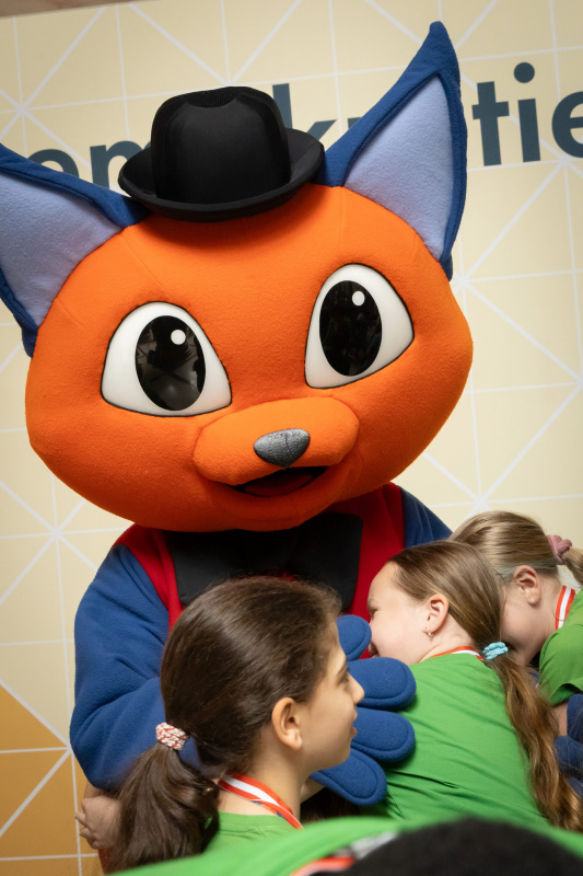 Maskottchen der Demokratiewerkstatt mit Schülerinnen und Schülern am Fotopoint in der Säulenhalle