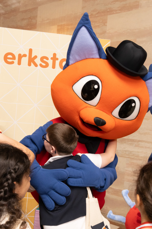 Maskottchen der Demokratiewerkstatt mit Schülerinnen und Schülern am Fotopoint in der Säulenhalle