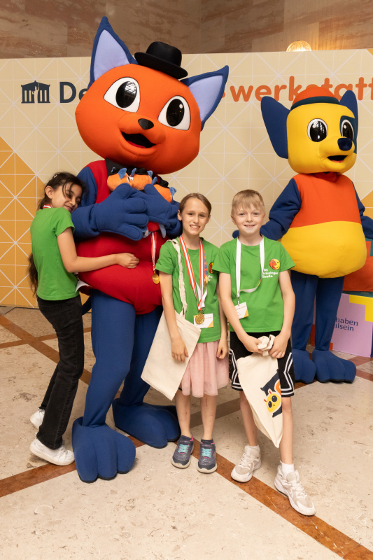 Maskottchen der Demokratiewerkstatt mit Schülerinnen und Schülern am Fotopoint in der Säulenhalle