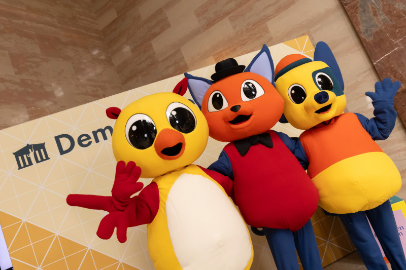 Maskottchen der Demokratiewerkstatt mit Schülerinnen und Schülern am Fotopoint in der Säulenhalle
