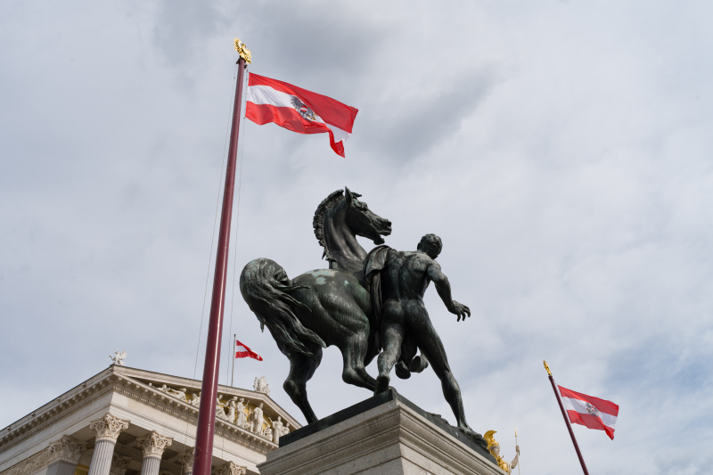 Gehisste Fahnen vor dem Parlamentsgebäude mit Rossebändiger