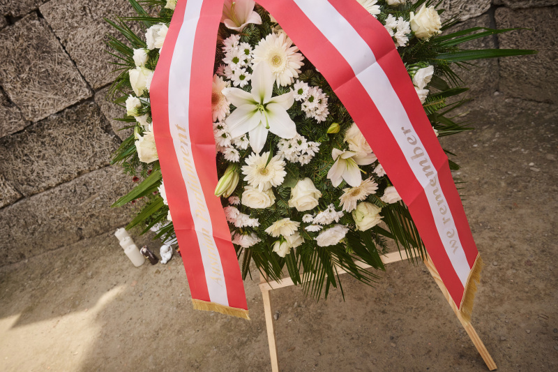 Gedenkzeremonie bei der „Wall of Death“. Kranz und Kranzschleife mit der Aufschrift „we rembember – Austrian Parliament“
