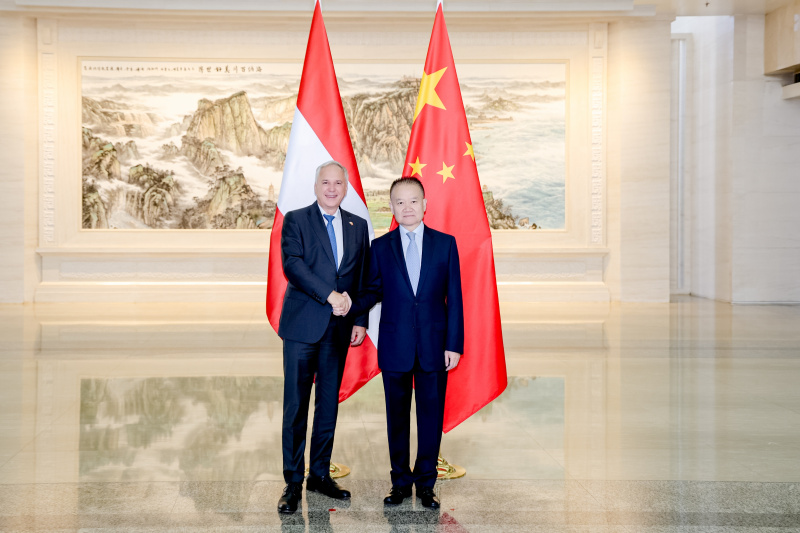 Fahnenfoto. Von links: Nationalratspräsident Walter Rosenkranz (FPÖ), Minister der Internationalen Abteilung des Zentralkomitees der Kommunistischen Partei Chinas Liu Haixing