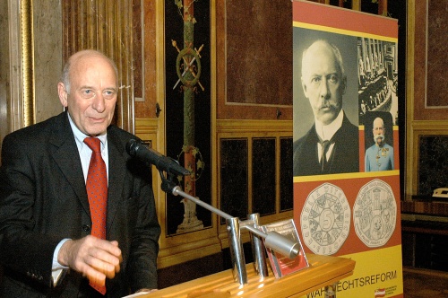 Dietrich Schüller vom Phonogrammarchiv der Österreichischen Akademie der Wissenschaften am Rednerpult. Plakat im Hintergrund.