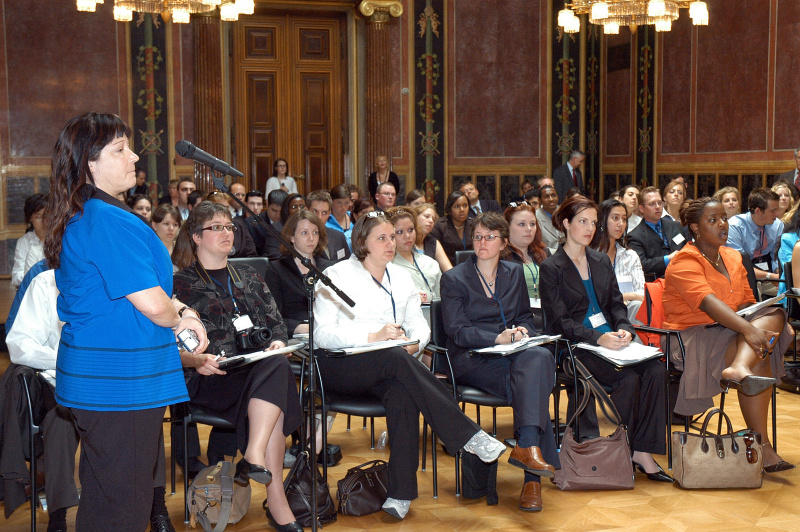 Blick in Richtung Veranstaltungsteilnehmer - US-Amerikanische Studenten. Eine Veranstaltungsteilnehmerin am Mikrofon.